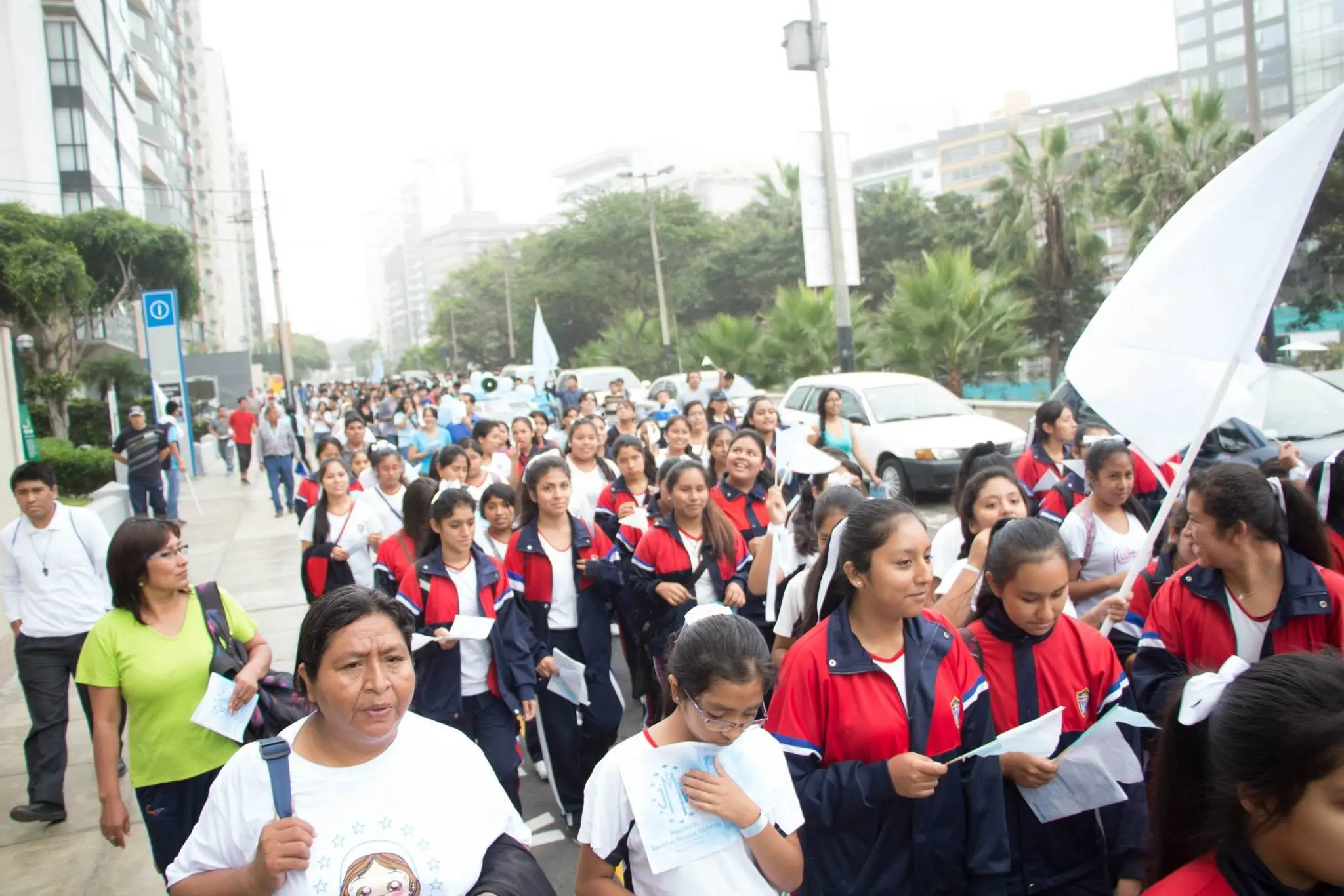 Multitud de escolares marchando con uniformes rojos y azules